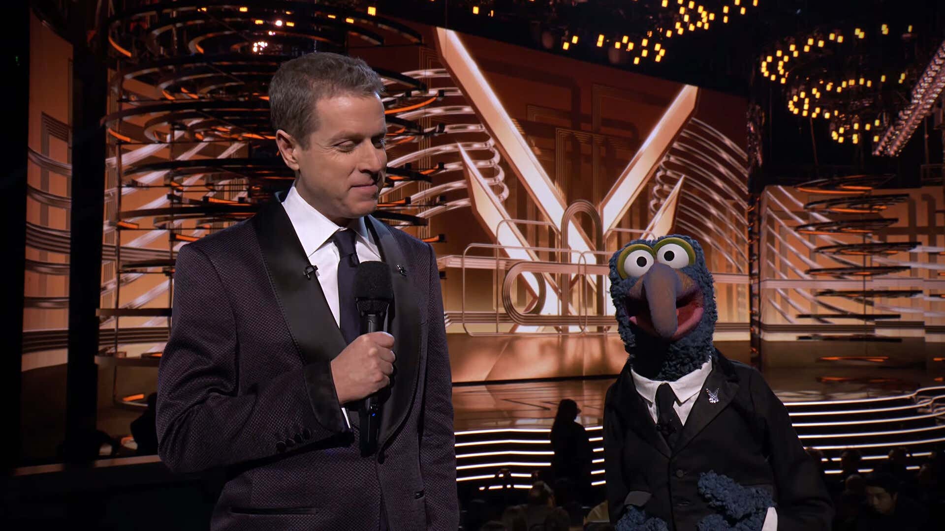 Geoff Keighley and Gonzo wear matching outfits on stage at The Game Awards 2023. 